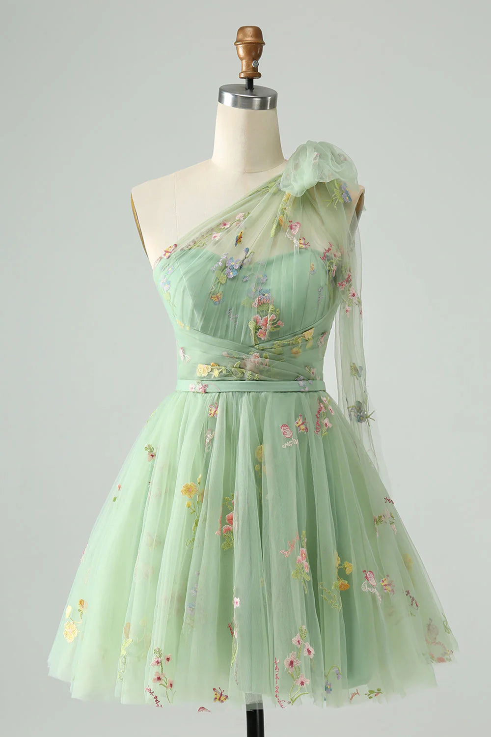 Light green A-line one shoulder tulle dress with floral embroidery.