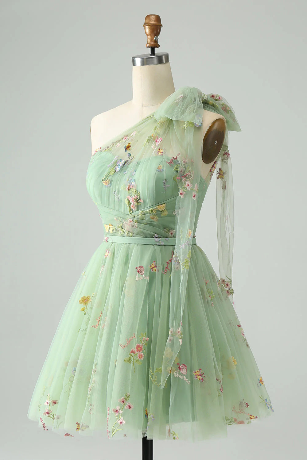 Close-up of floral embroidery on the light green tulle homecoming dress.