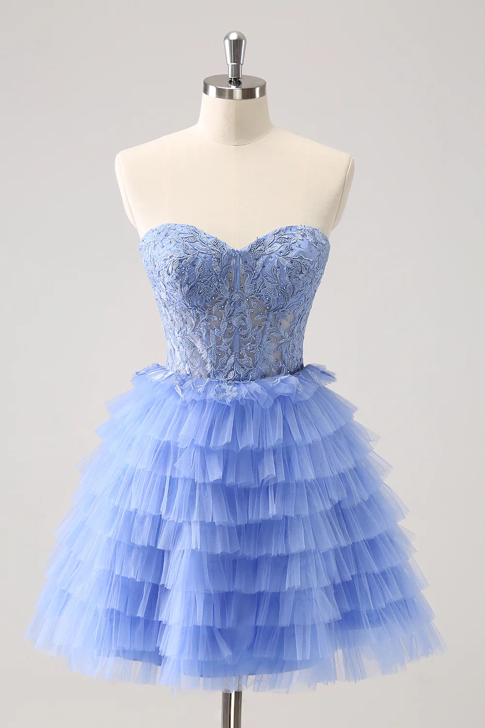 Model wearing a lilac A-line formal gown with sweetheart neckline and tiered skirt.