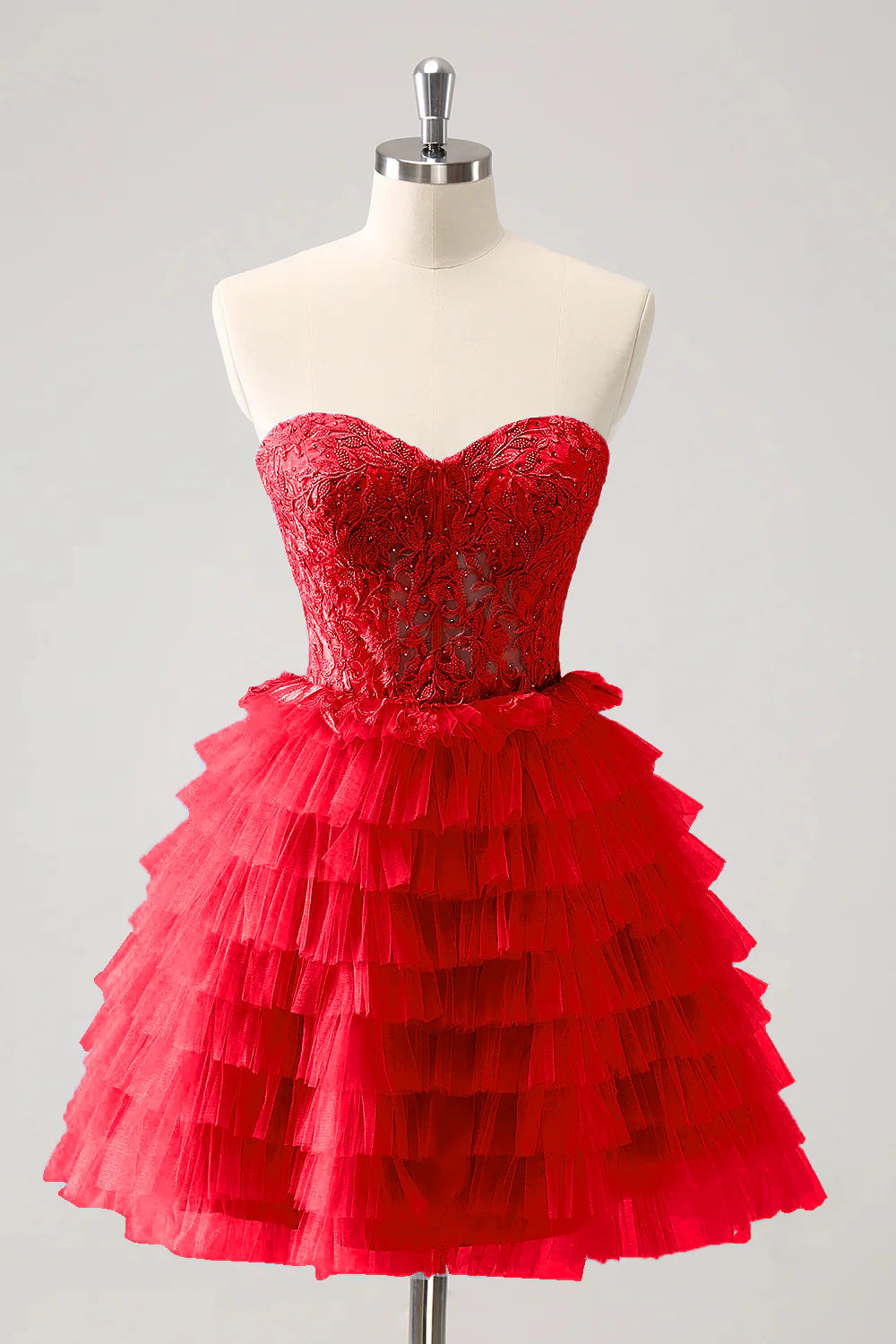 Model wearing a red A-line formal gown with sweetheart neckline and tiered skirt.