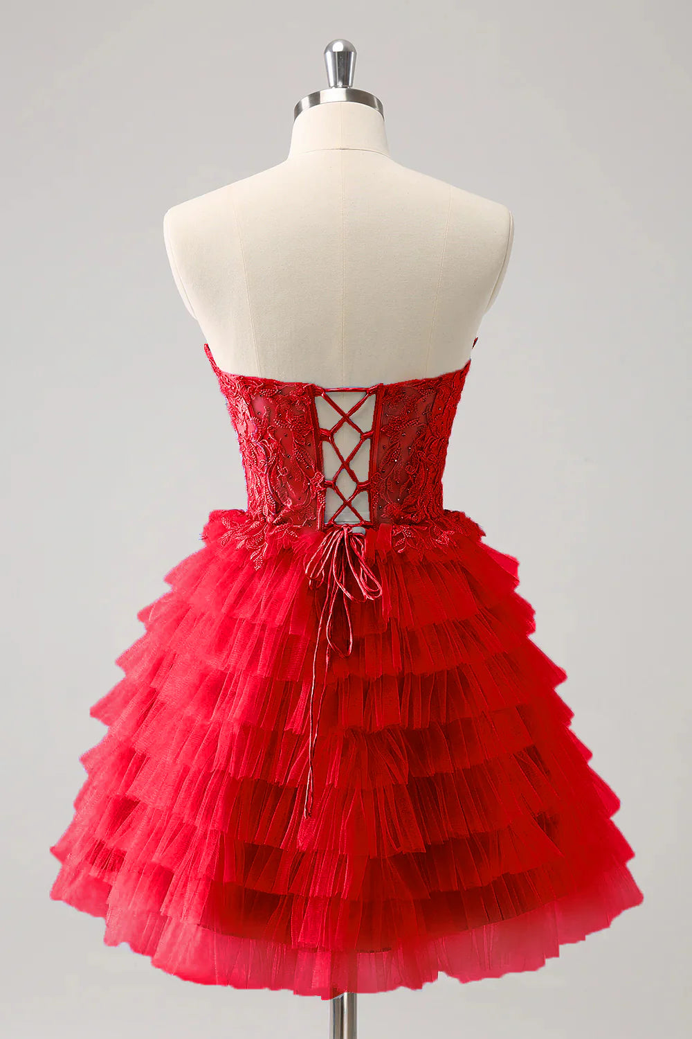 Side view of a red A-line formal gown, showing the tiered layers and elegant drape.