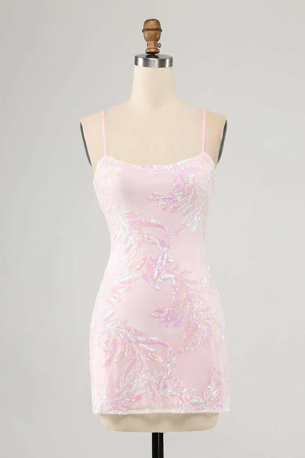 Front view of a model wearing a pink bodycon spaghetti strap homecoming dress.