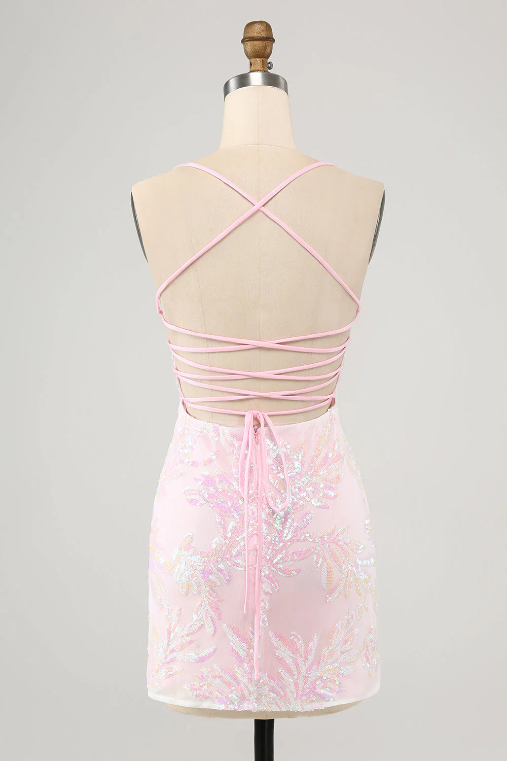 Back view of a model wearing a pink bodycon dress with criss-cross spaghetti straps.