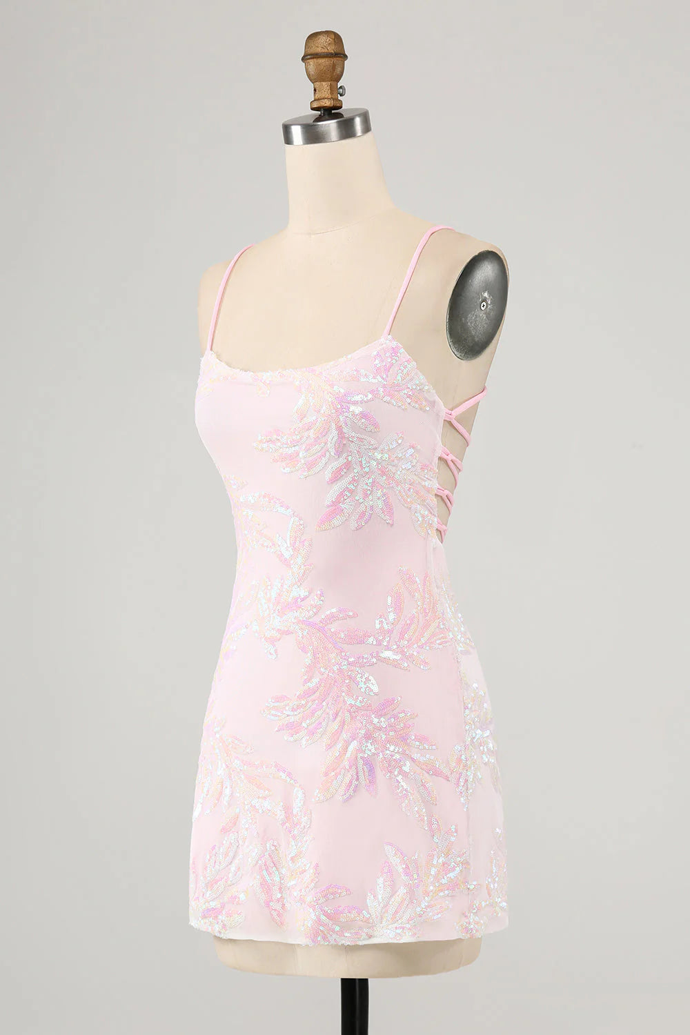 Side view of a model wearing a pink bodycon spaghetti strap formal dress.