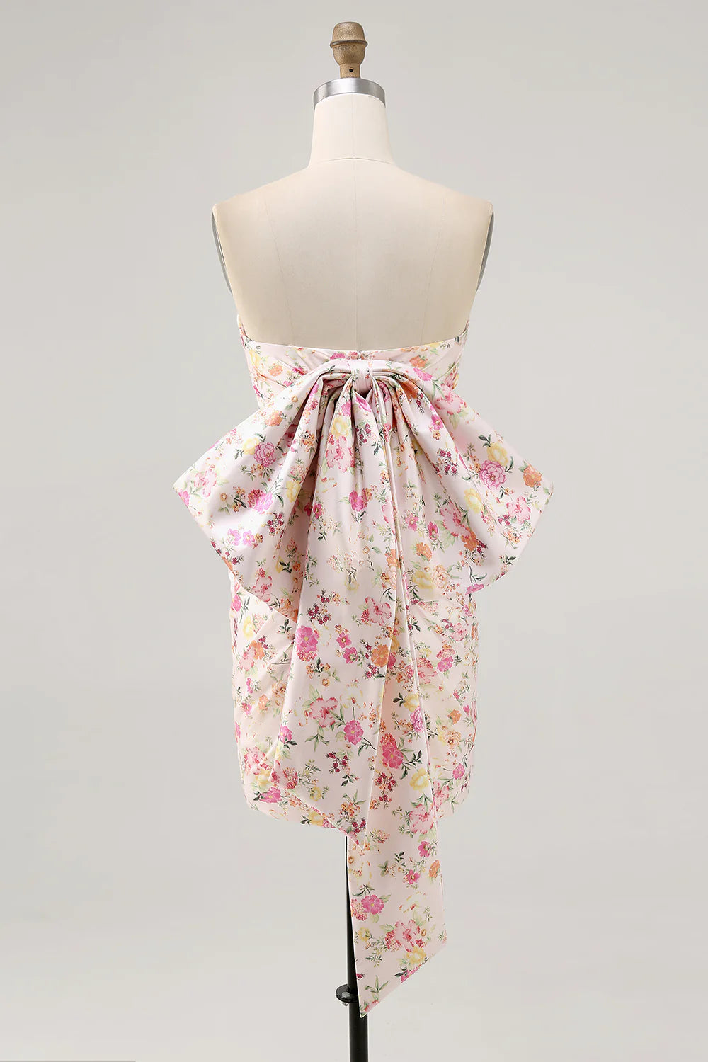 Side view of a pink strapless bodycon dress with ruched details and a bow.
