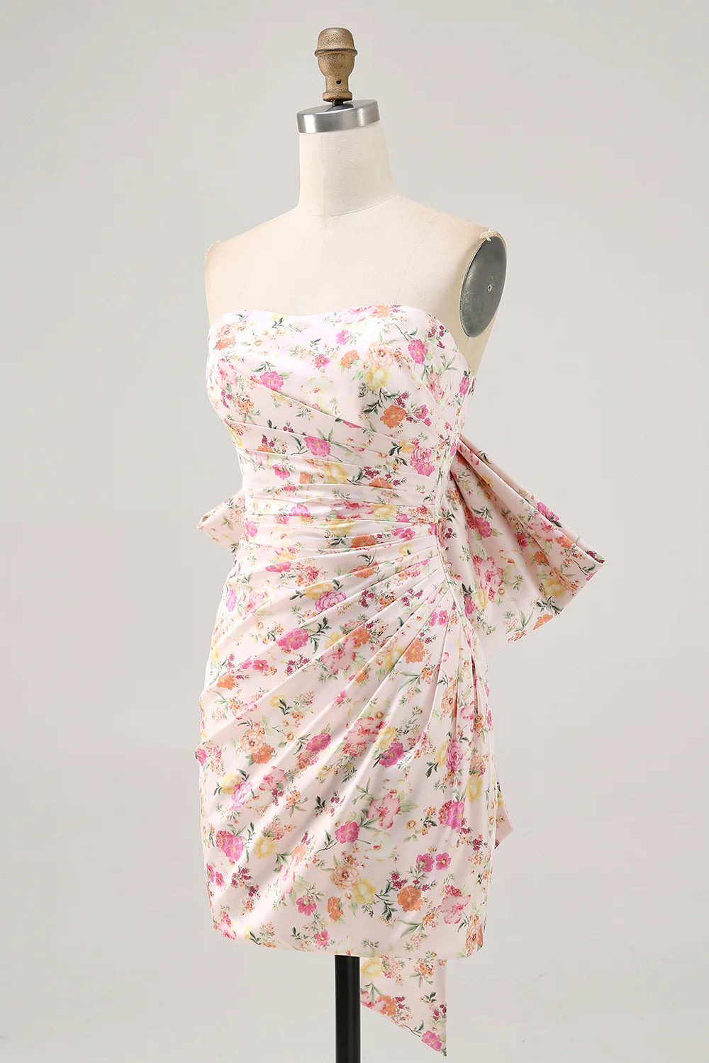 Back view of an elegant pink short homecoming dress with a prominent bow.