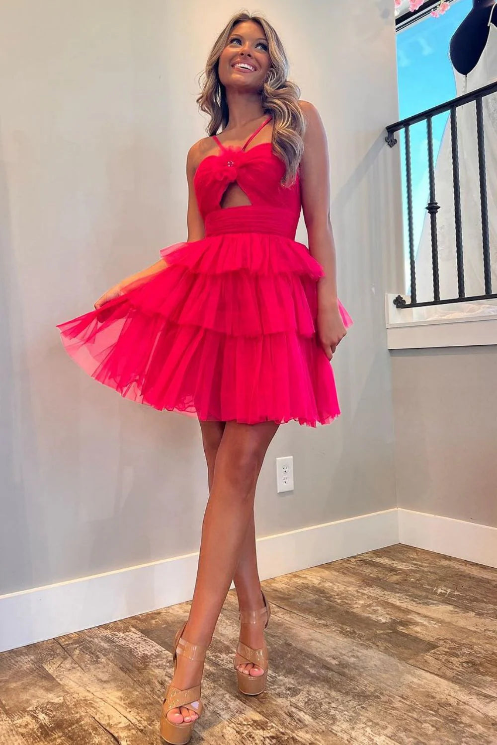Model wearing a red A-line halter neck short tiered tulle homecoming dress.