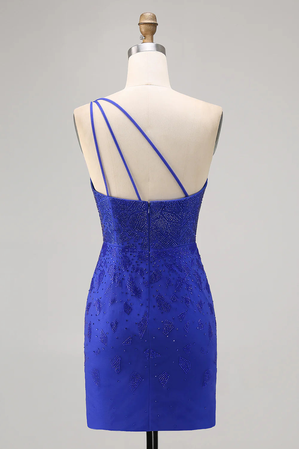 Model wearing a royal blue bodycon one-shoulder beaded homecoming dress with a high slit, side view.