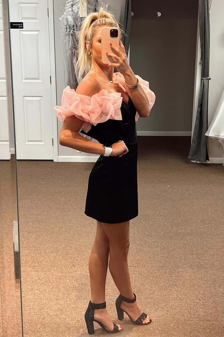 Model wearing a fitted black strapless mini dress.