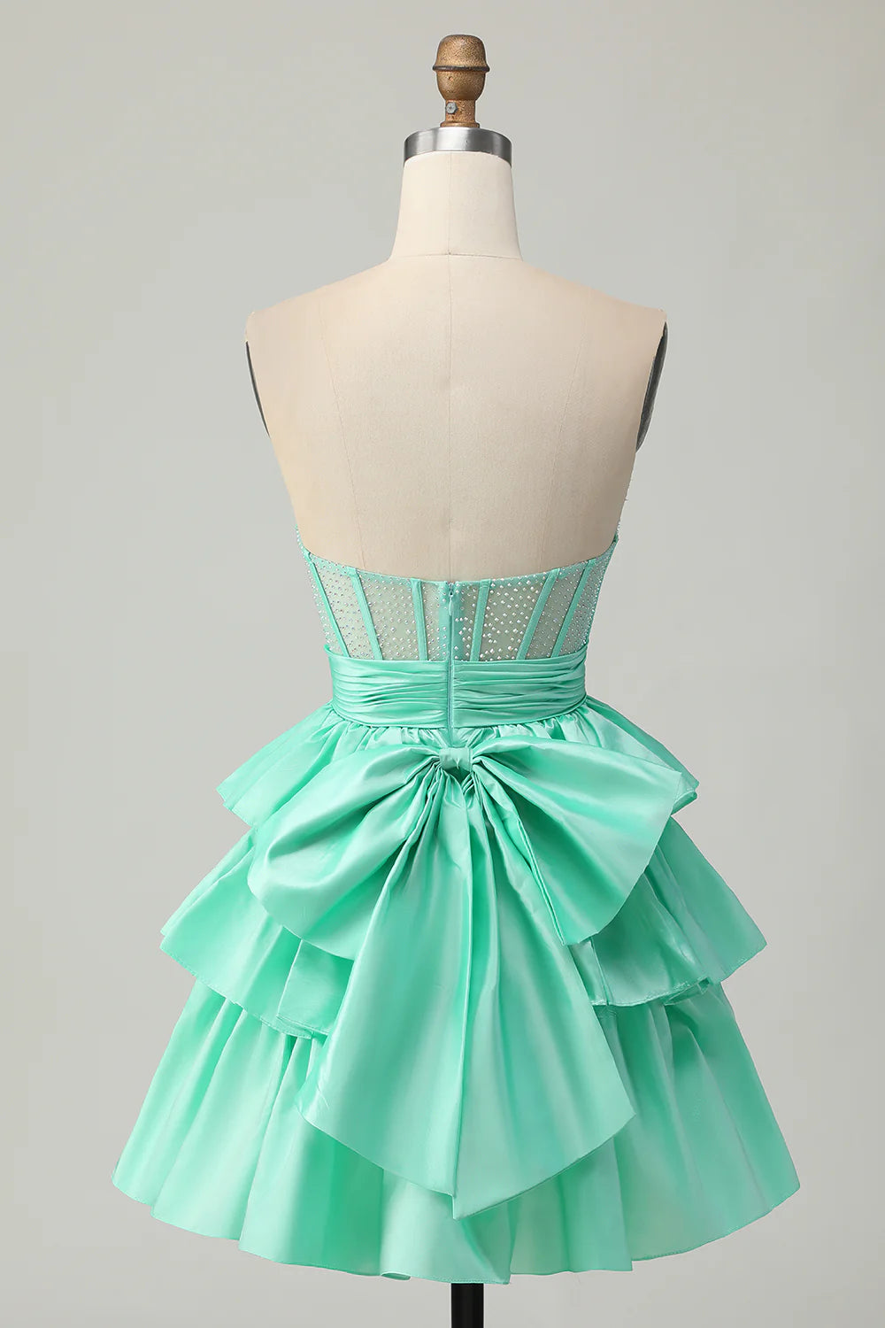 Back view of strapless A-line tiered homecoming dress with corset and bow.