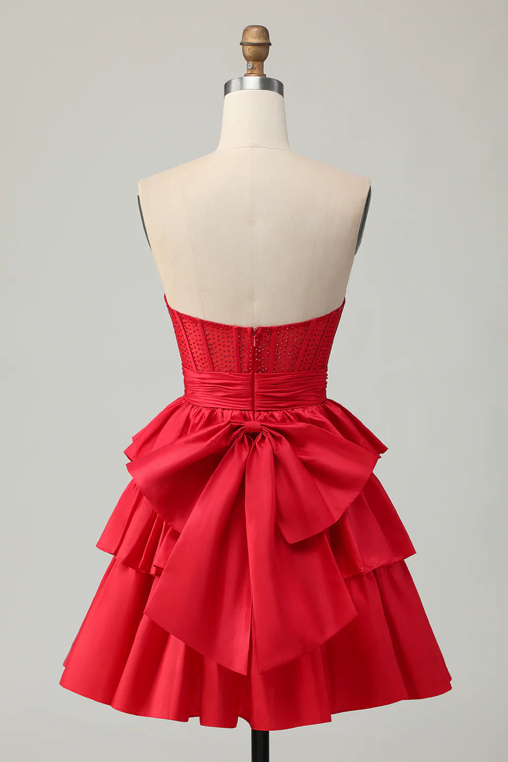Model posing in strapless A-line homecoming dress with tiered skirt.