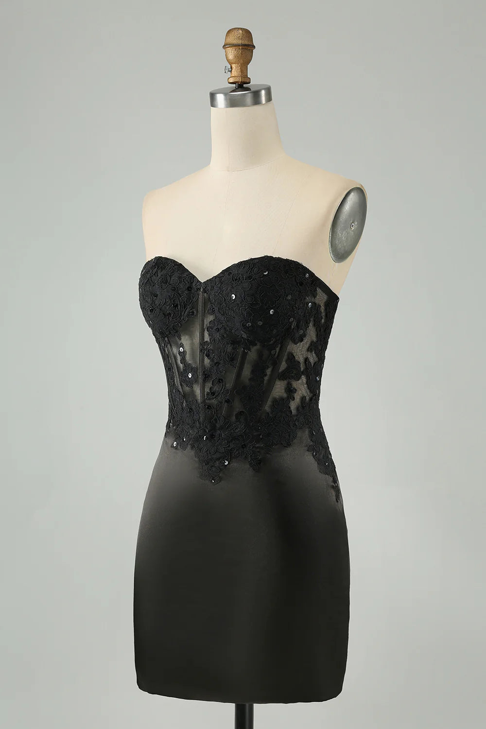 Back view of a black bodycon dress with corset detailing and appliques.