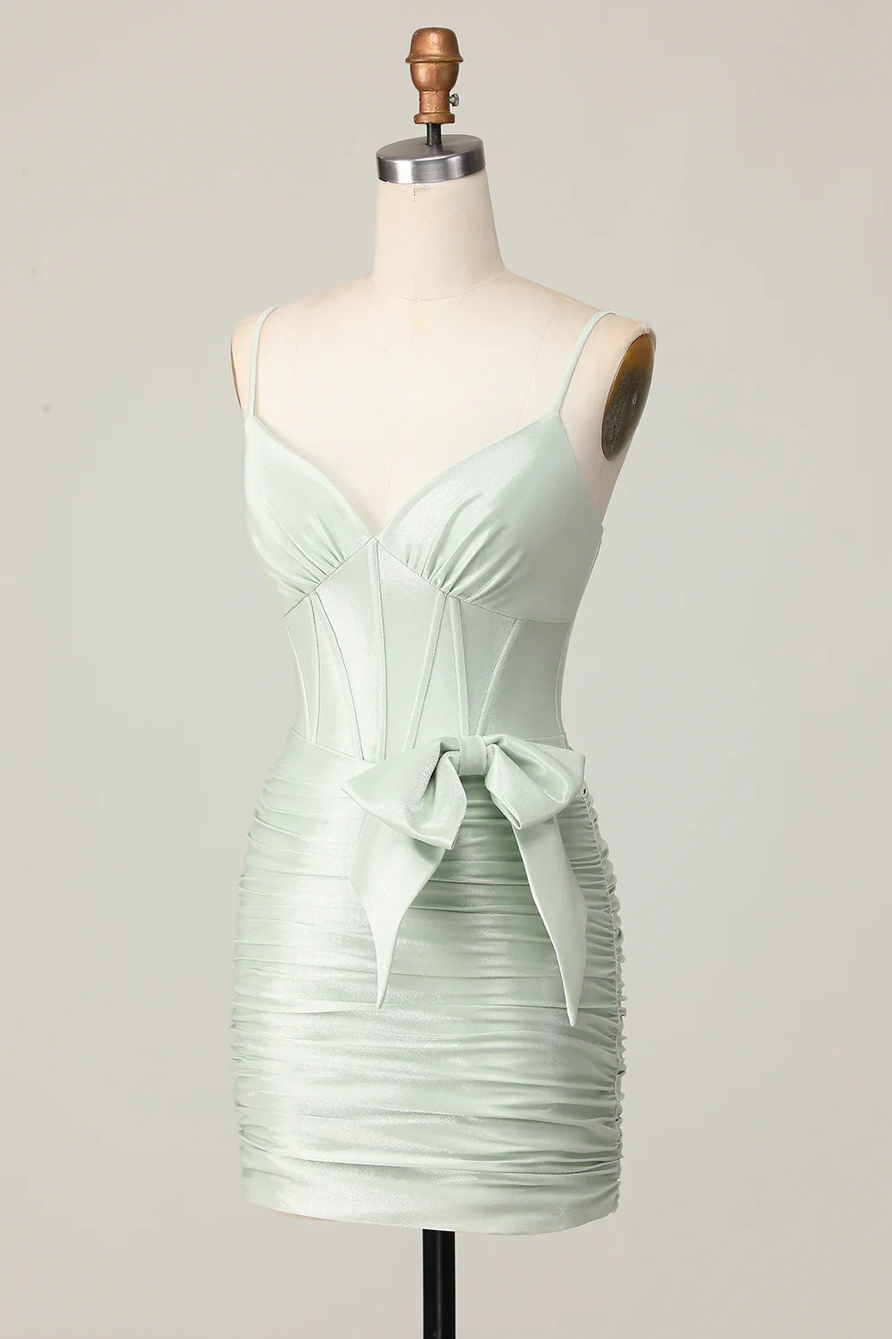 Side view of sage short formal dress, showing bow and ruched details.