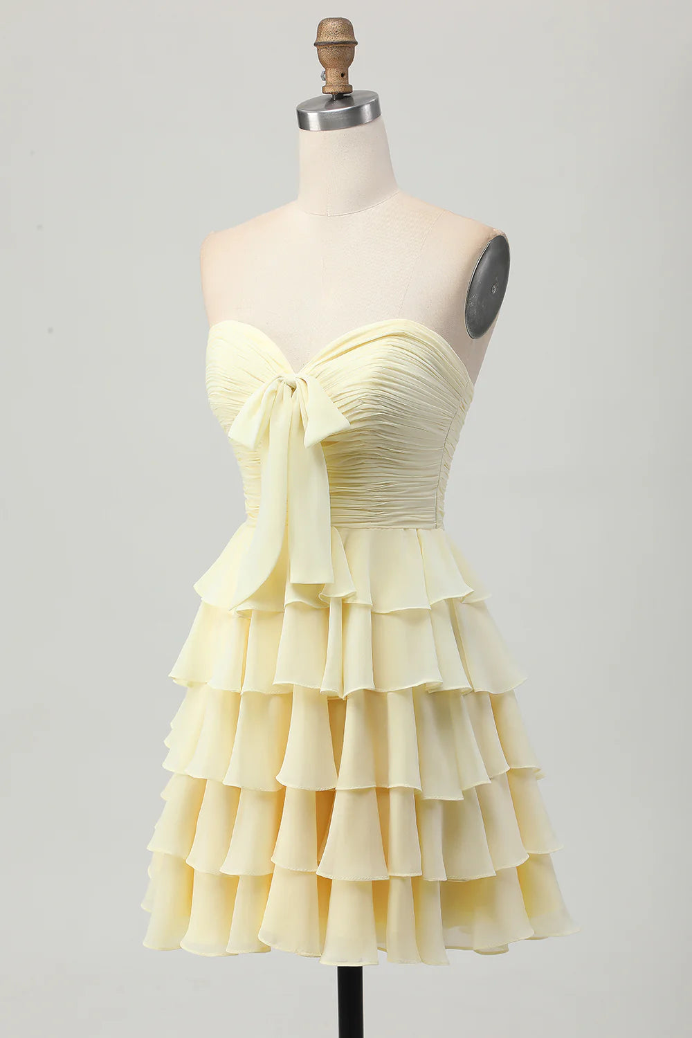 Back view of the elegant light yellow tiered short dress.
