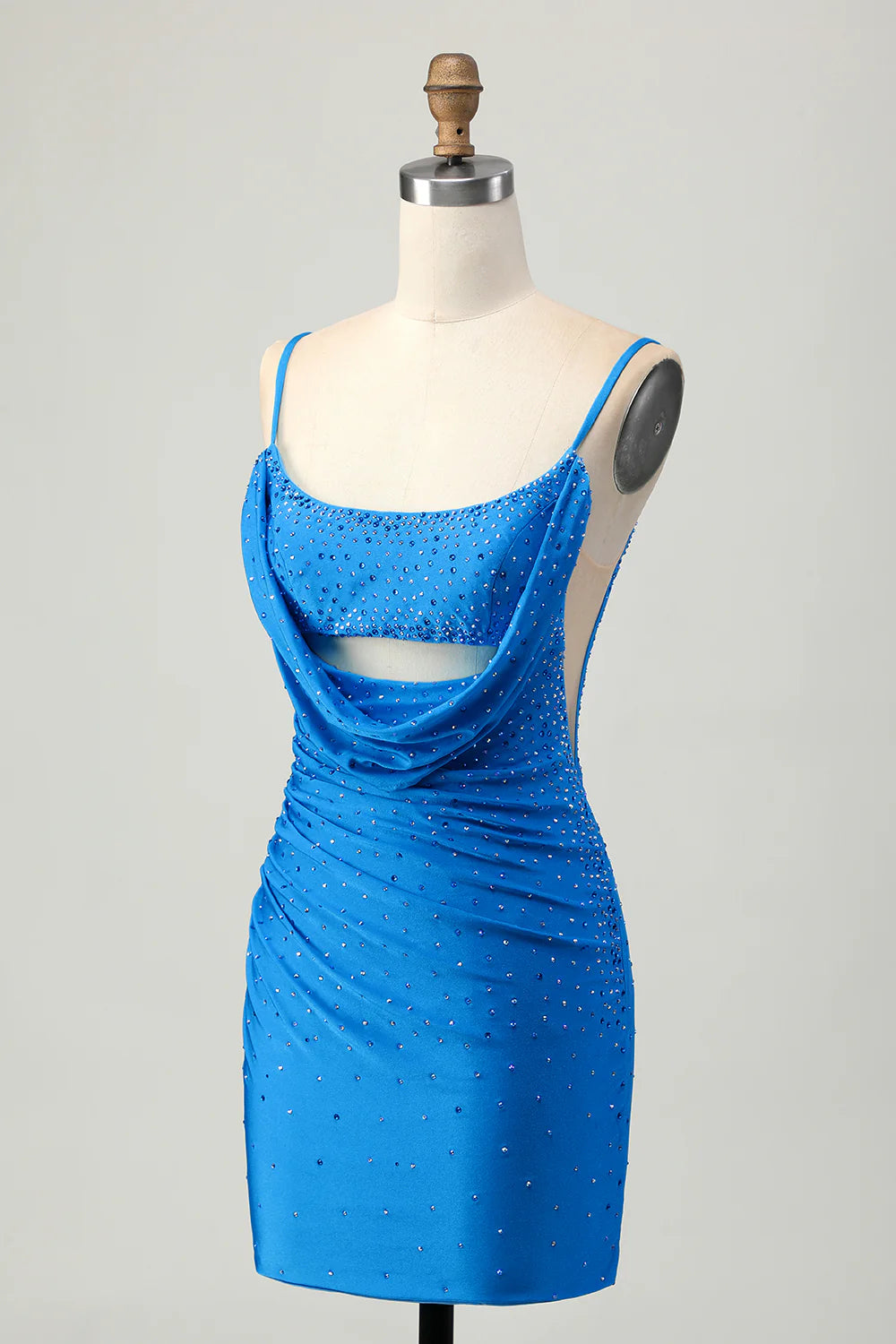 Side profile of a woman in a tight cut out short blue homecoming dress, highlighting the silhouette.