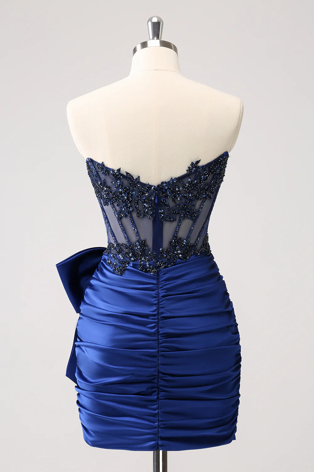 Back view of a navy strapless pleated short dress, showcasing corset lacing.