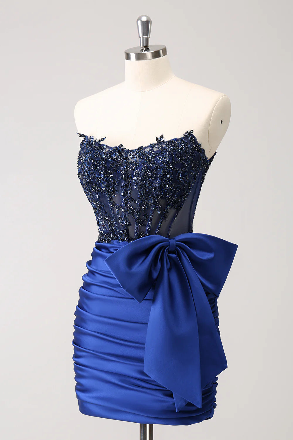Close-up of the navy strapless dress, highlighting beaded embellishments and a bow.