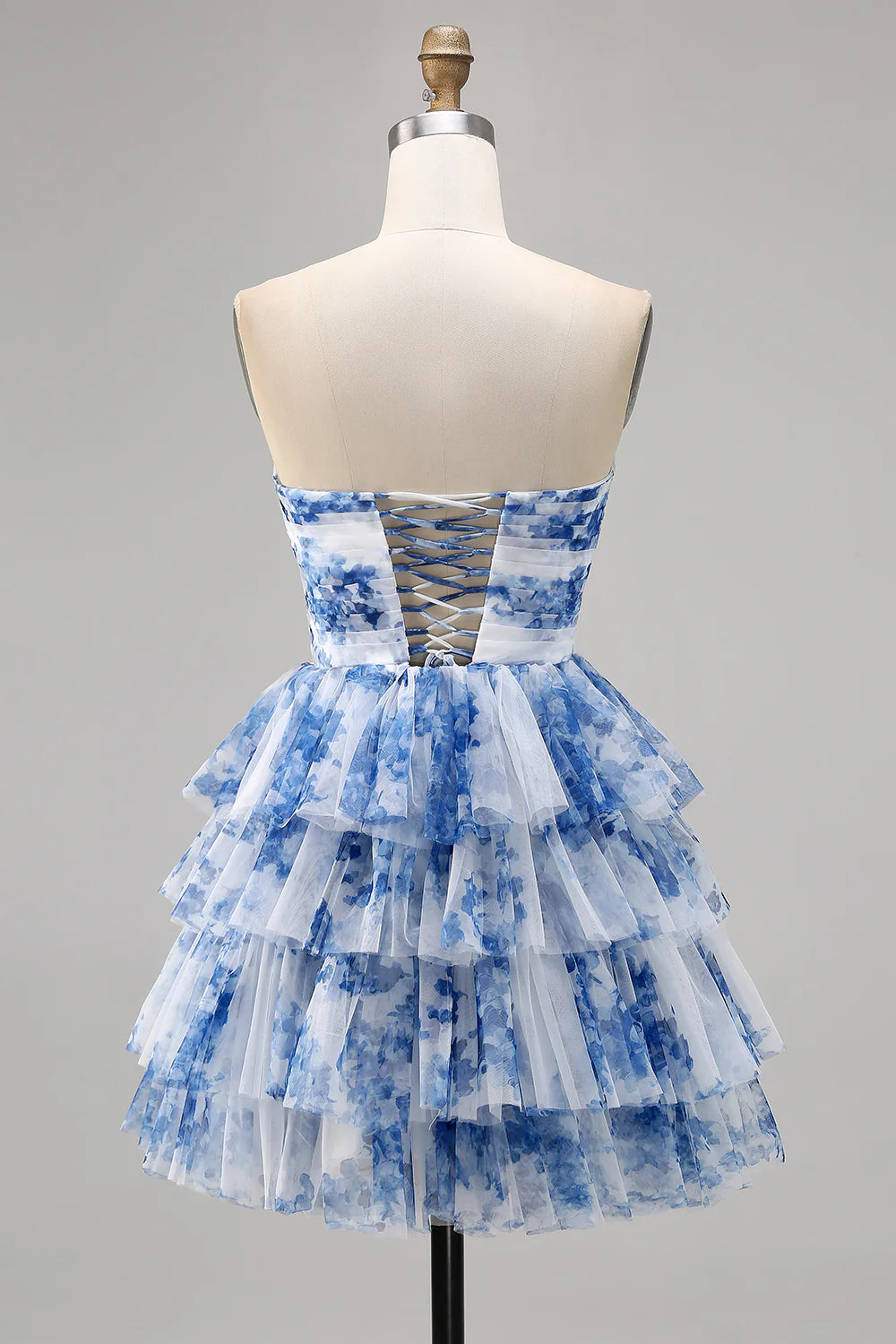 Side view of white and blue floral tiered homecoming dress.