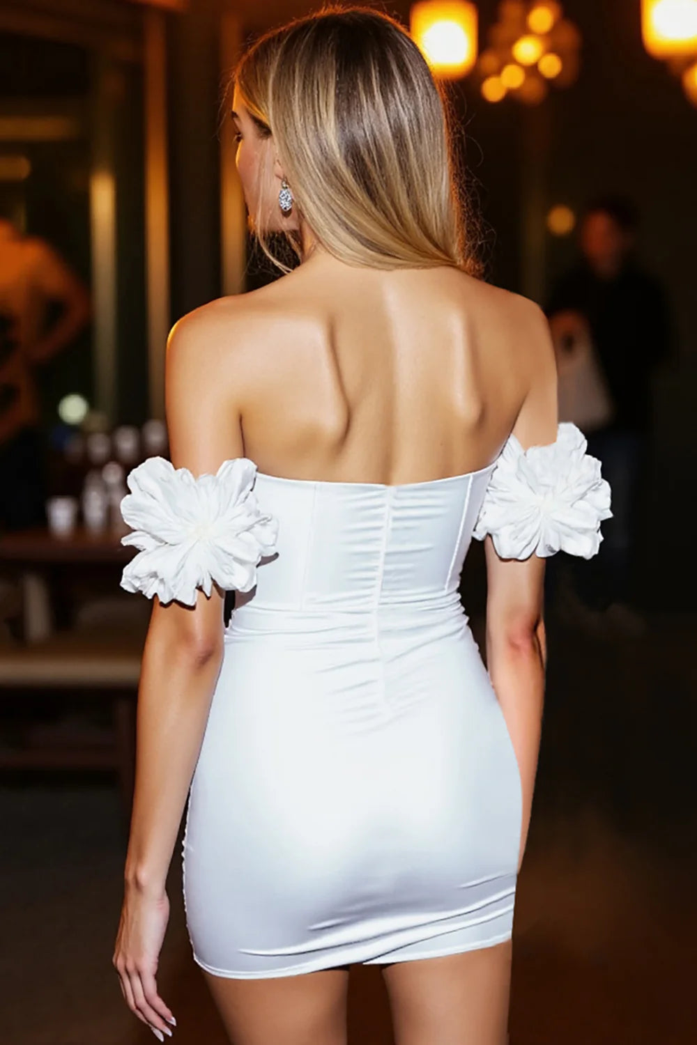 Model wearing a white bodycon off-the-shoulder homecoming dress with ruffled sleeves, side view.