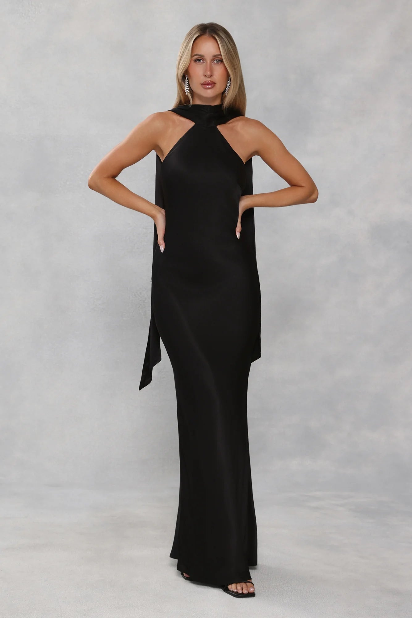 Glamorous Black Satin Halter Neck Maxi Dress with High Neck Draped Cape Overlay, Open Back Tie Closure, Form-Fitting Mermaid Silhouette and Floor-Length Flowing Skirt