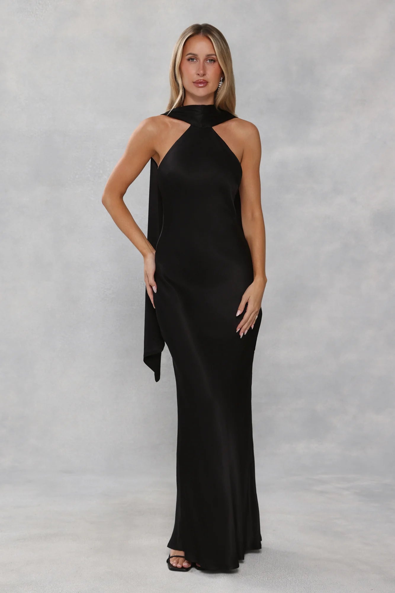 Glamorous Black Satin Halter Neck Maxi Dress with High Neck Draped Cape Overlay, Open Back Tie Closure, Form-Fitting Mermaid Silhouette and Floor-Length Flowing Skirt