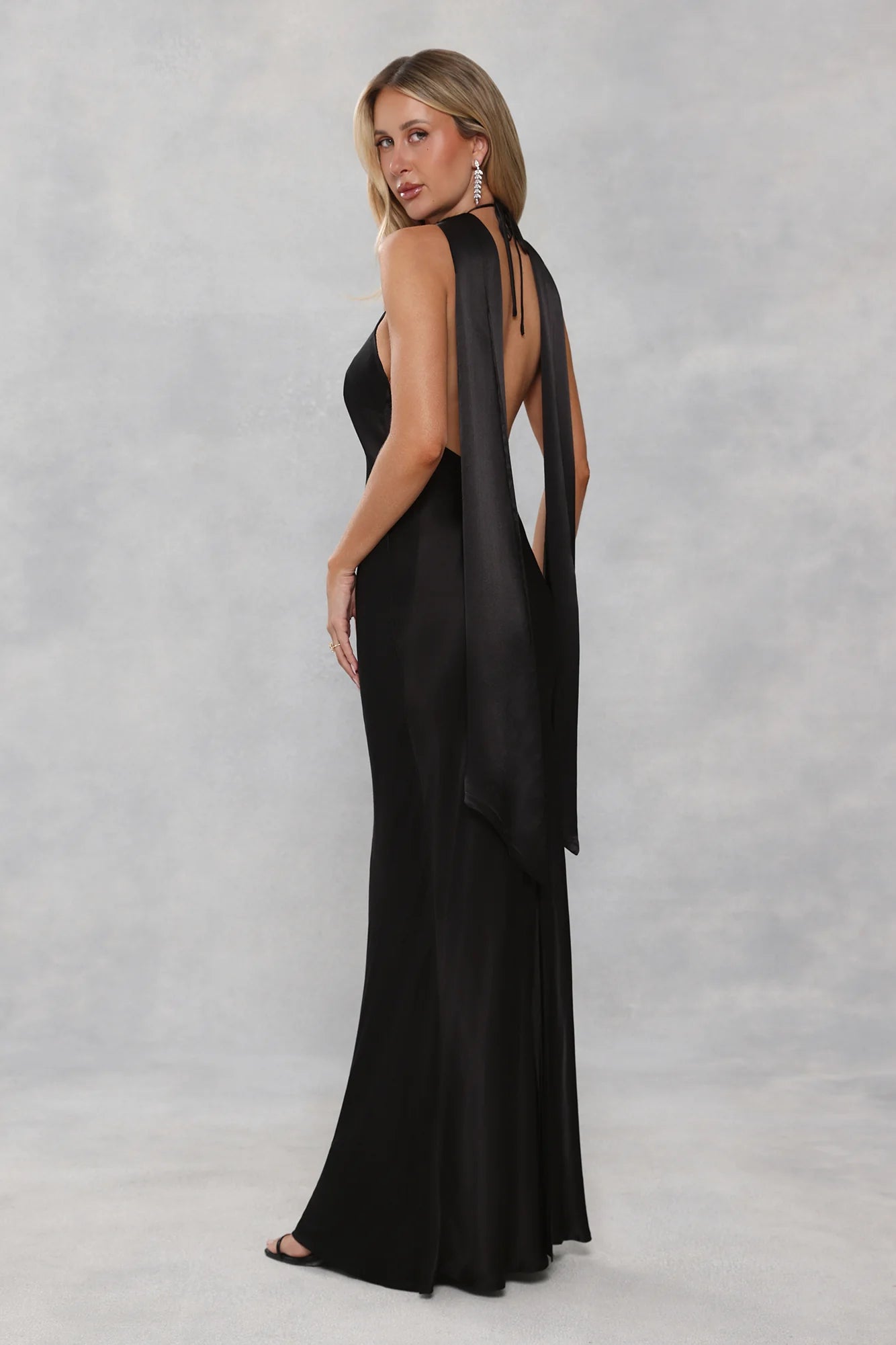 Glamorous Black Satin Halter Neck Maxi Dress with High Neck Draped Cape Overlay, Open Back Tie Closure, Form-Fitting Mermaid Silhouette and Floor-Length Flowing Skirt