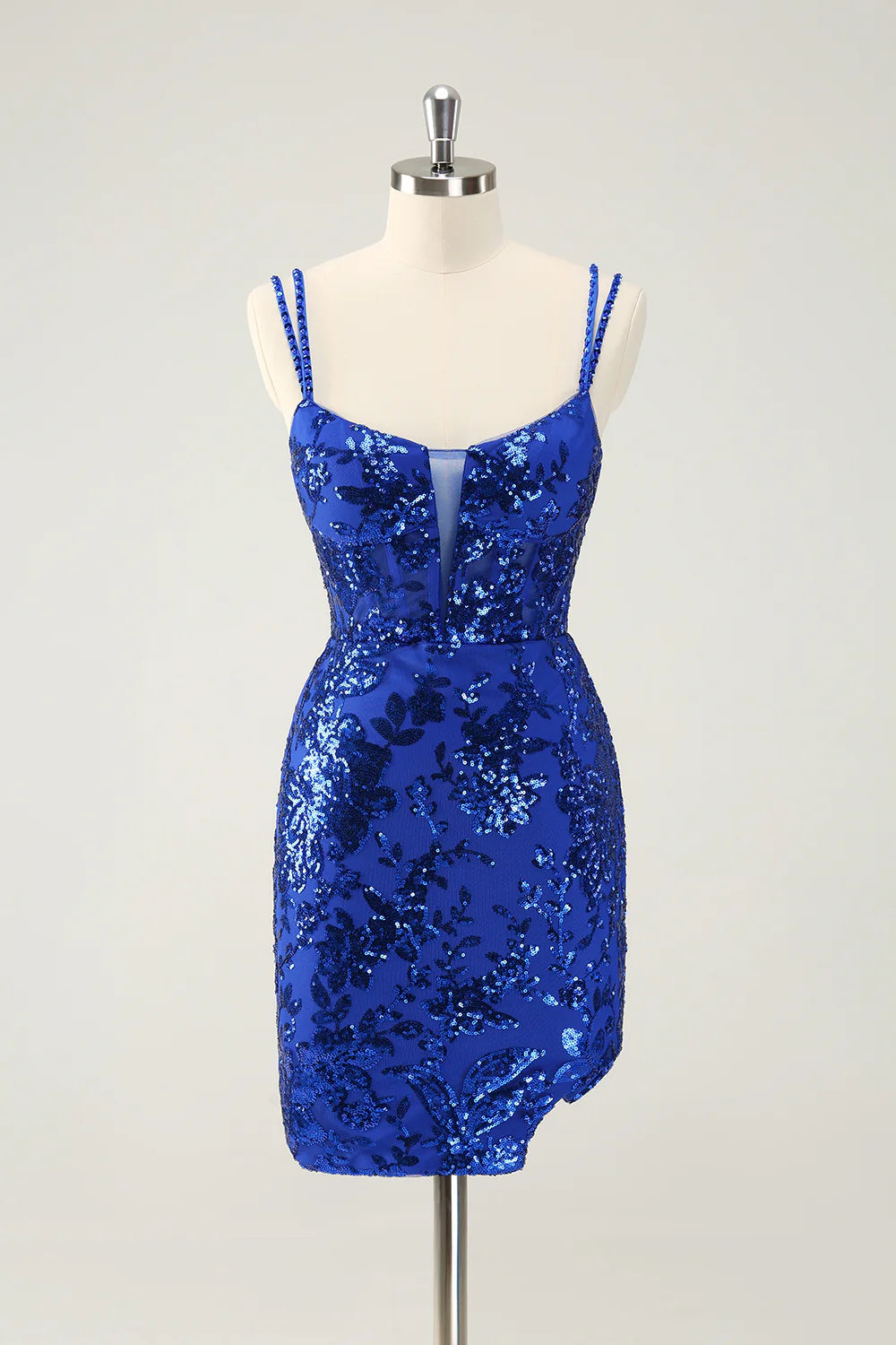 Model in a glitter royal blue short homecoming dress with spaghetti straps and a side slit.