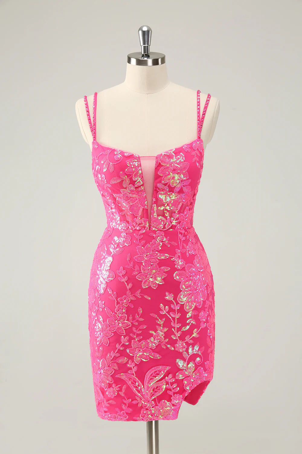 Model in a glitter hot pink short homecoming dress with spaghetti straps and a side slit.