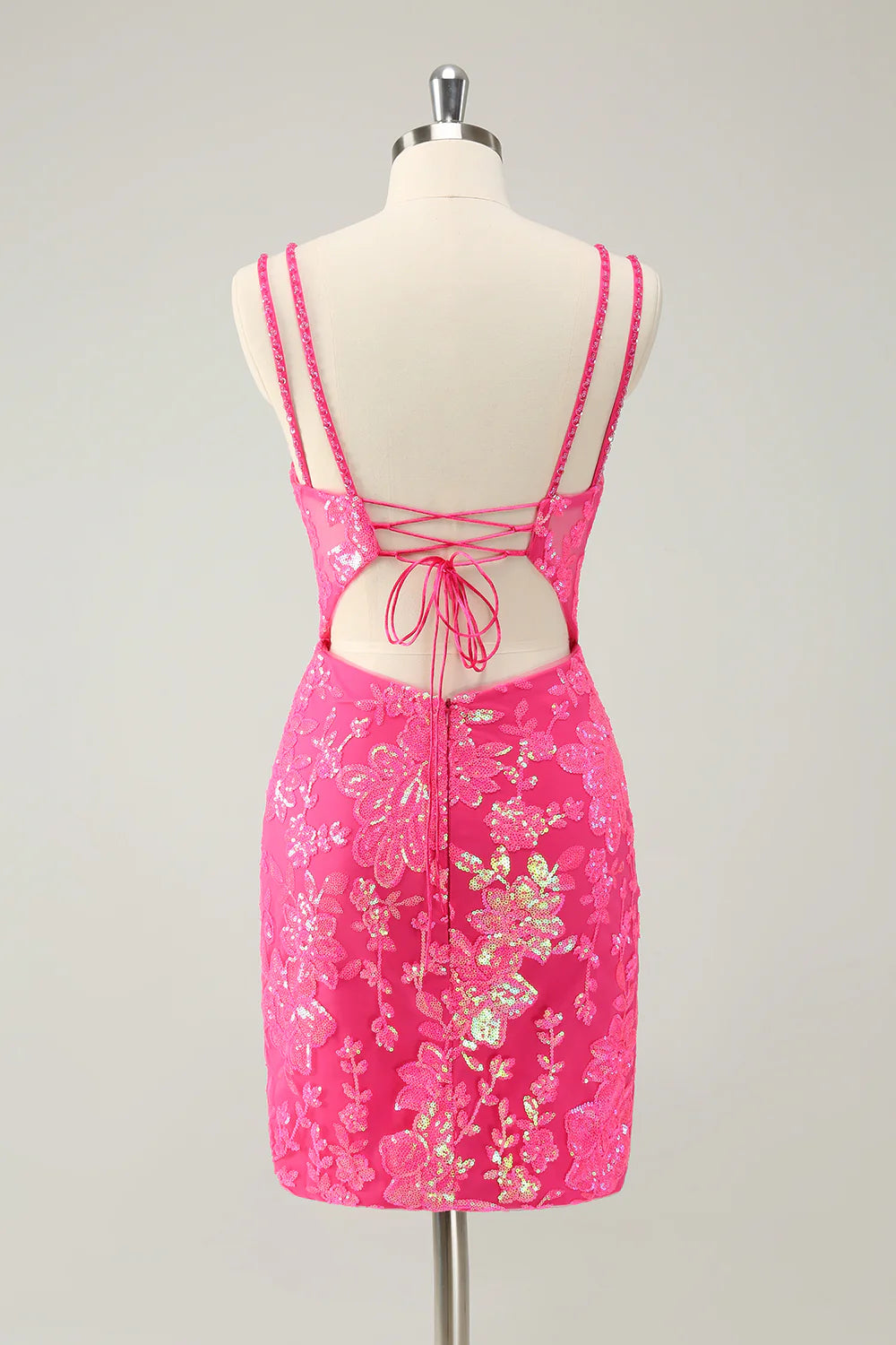 Back view of a glitter hot pink short homecoming dress with lace-up detail.