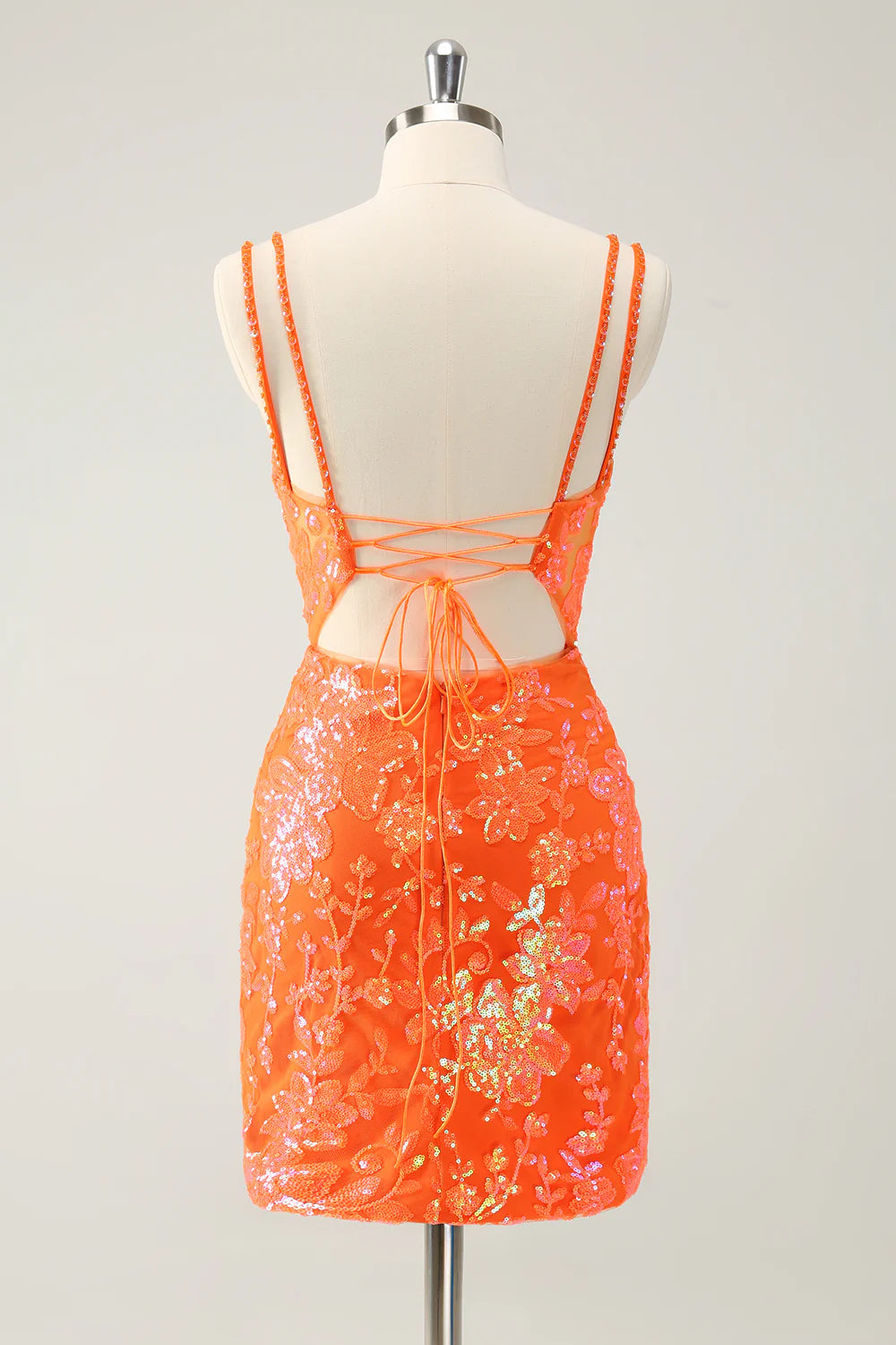 Back view of a glitter orange short homecoming dress with lace-up detail.