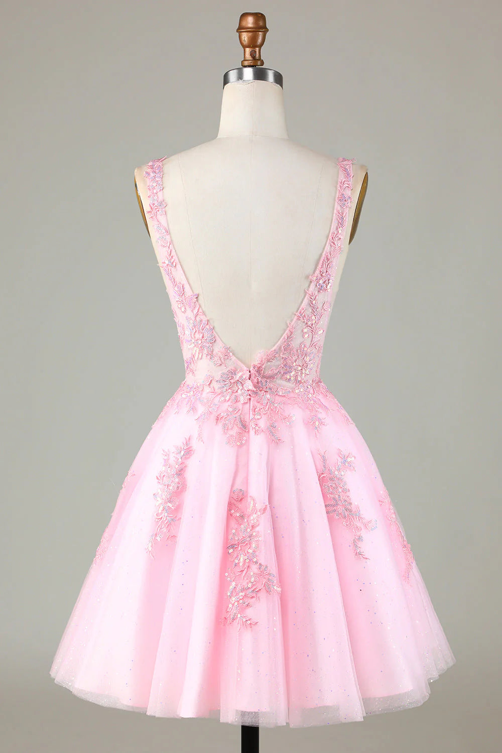 Close-up of the backless design and sequin appliques on the pink dress.