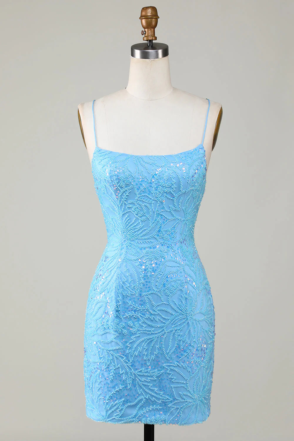Front view of a model wearing a shimmering blue short homecoming dress with spaghetti straps and beading.