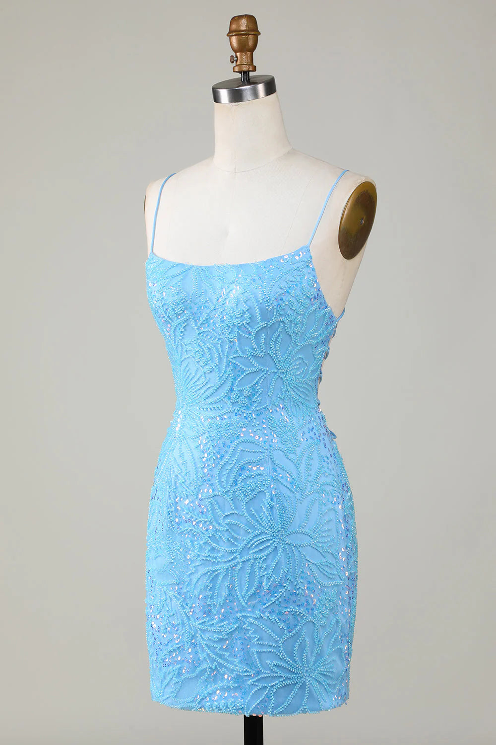 Back view of a model wearing a blue beaded spaghetti strap short dress, highlighting the intricate details.