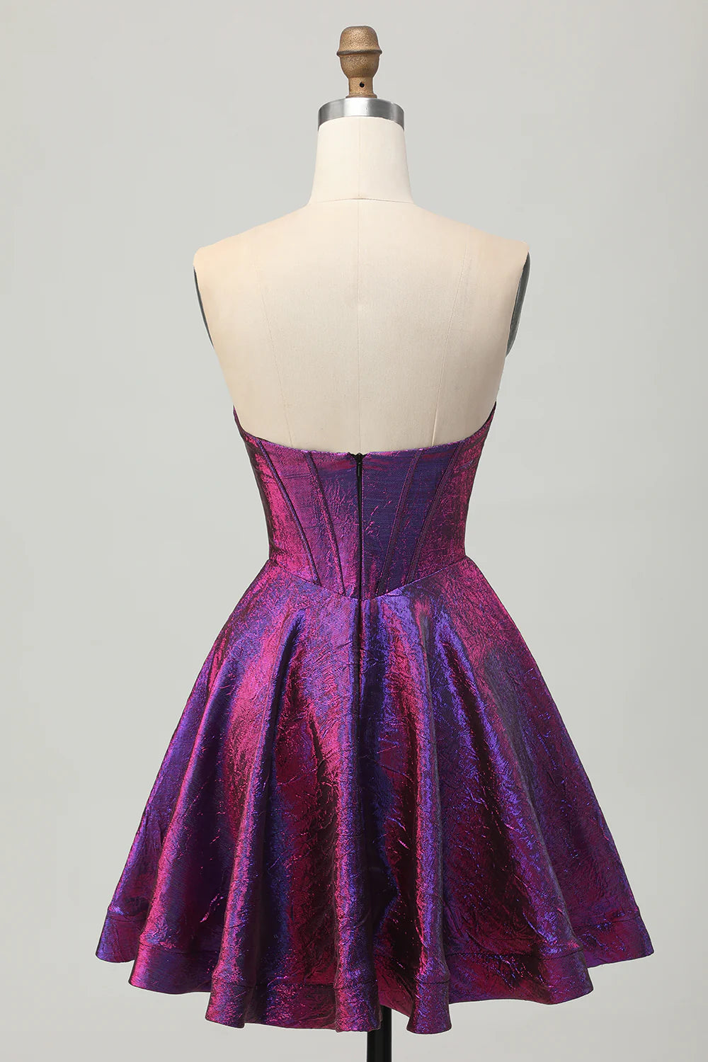 Model wearing a metallic dark purple A-line strapless short homecoming dress, side view.