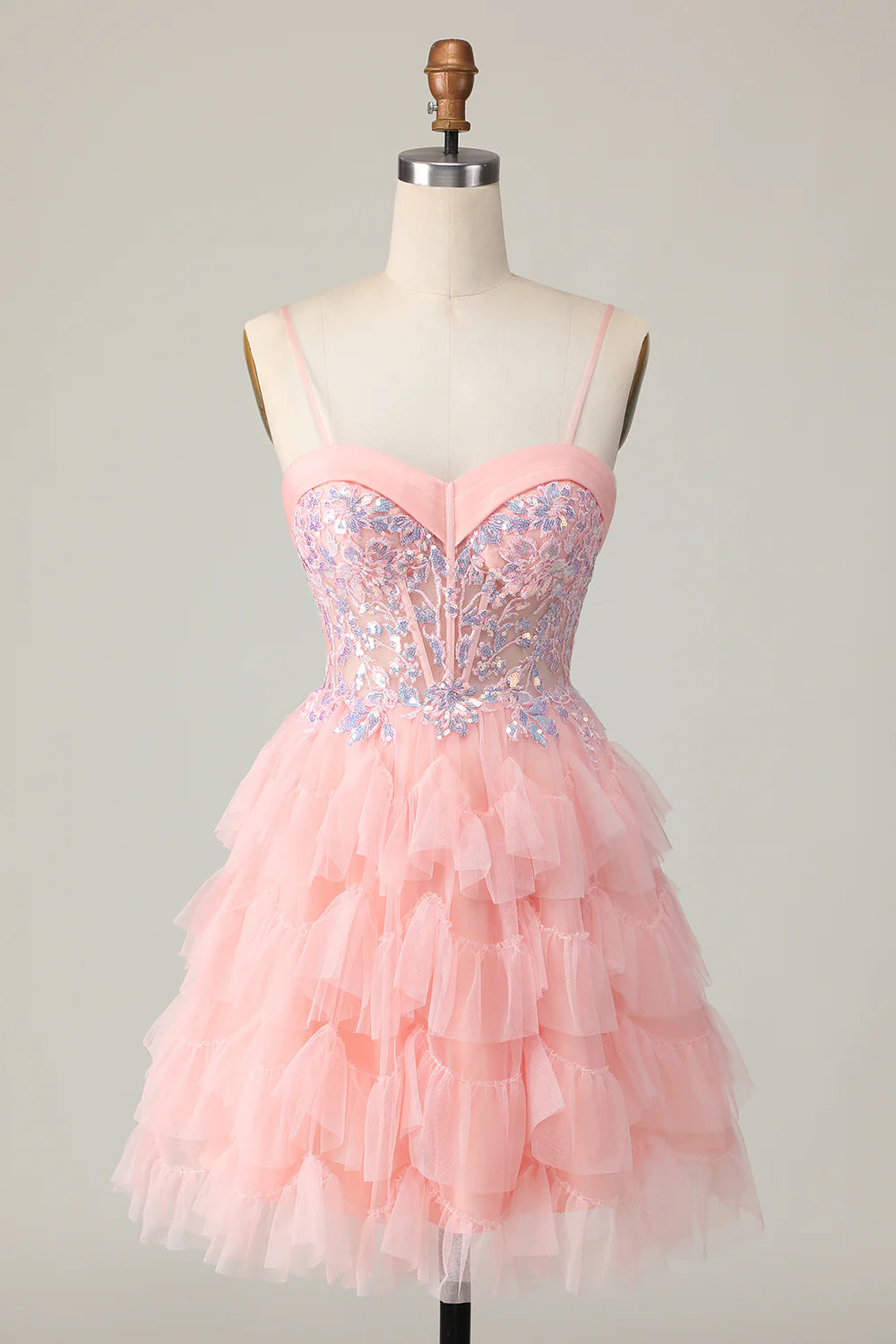 Front view of a pink tiered A-line homecoming dress with sequins and ruffles.