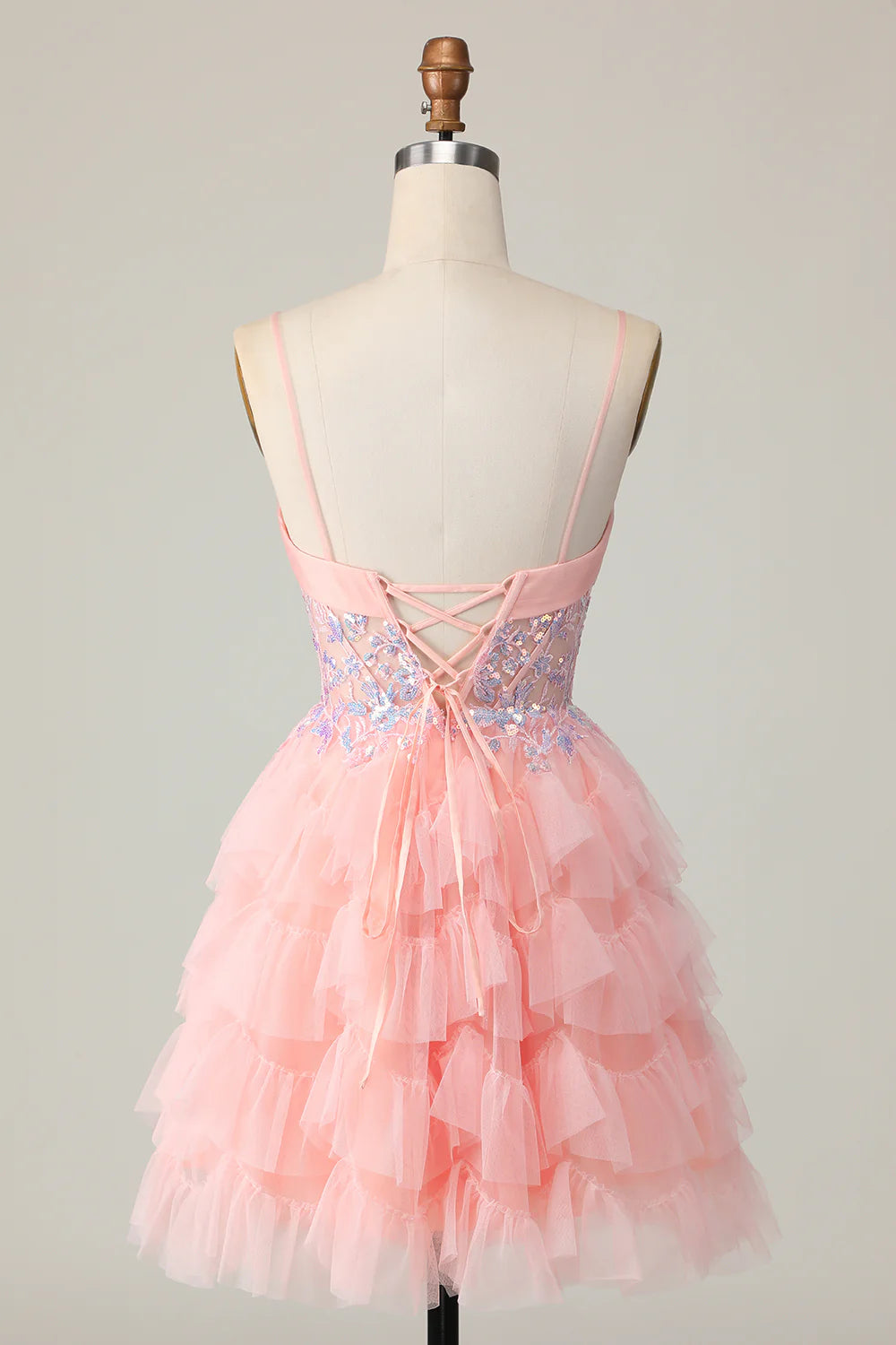 Side view of a pink tiered A-line homecoming dress with sequins and ruffles.