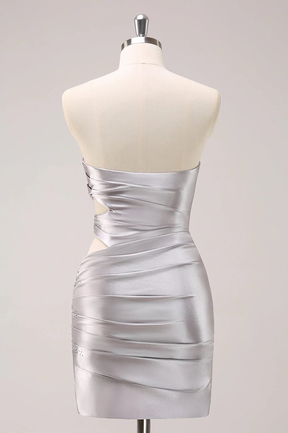 Back view of a model in a silver strapless pleated mini dress, showcasing the fitted silhouette.