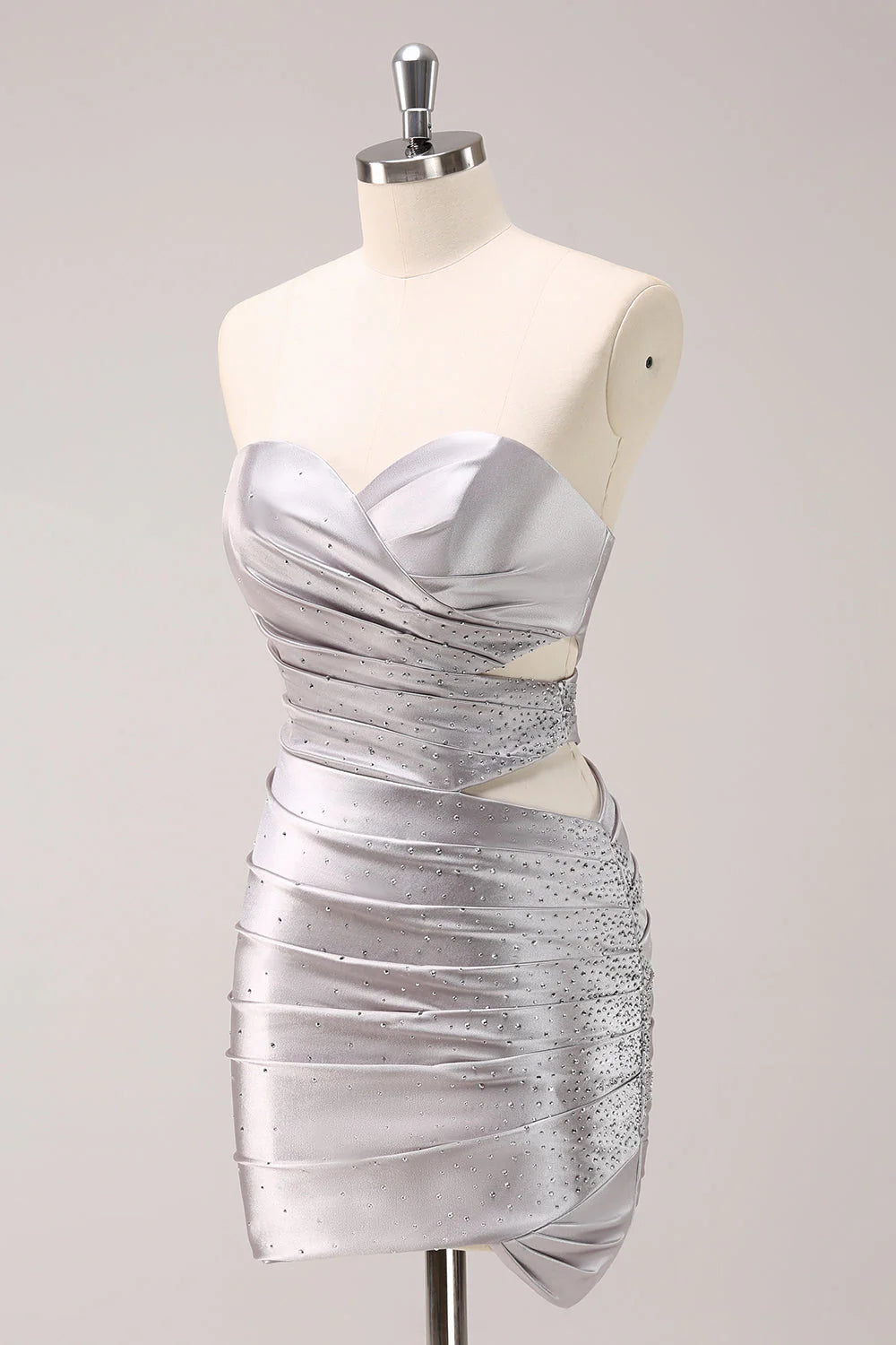 Close-up of the silver metallic fabric, pleating, and delicate beading on the strapless dress.