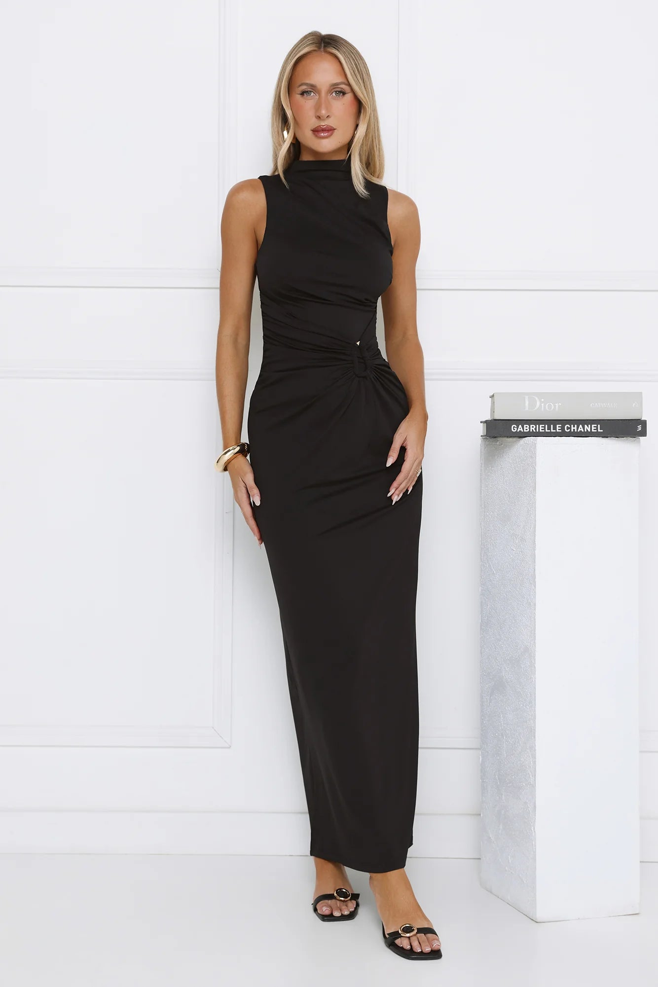 Sleek Black Sleeveless High Neck Maxi Dress with Ruched Waist Knot Detail, Form-Fitting Silhouette and Floor-Length Skirt