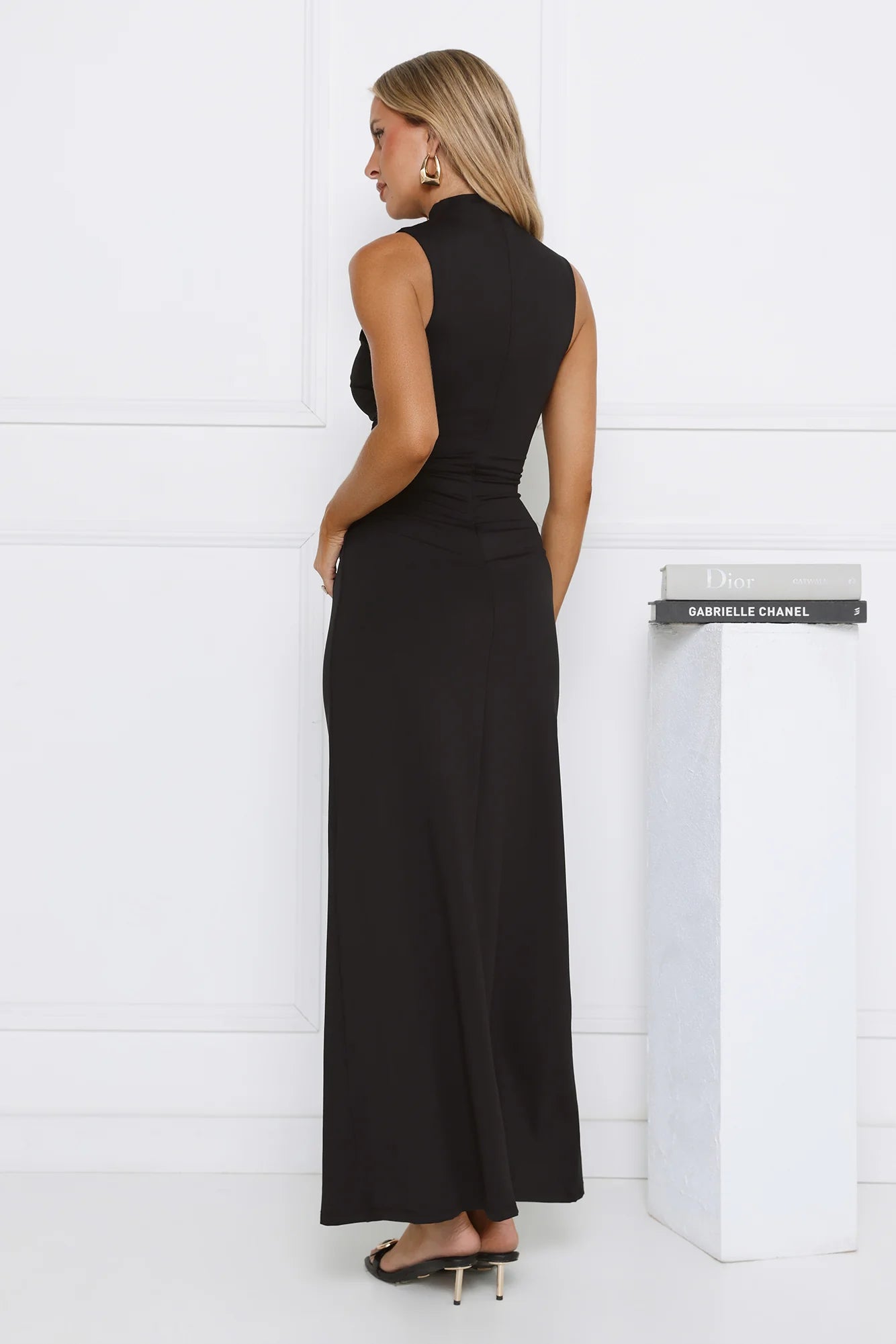 Sleek Black Sleeveless High Neck Maxi Dress with Ruched Waist Knot Detail, Form-Fitting Silhouette and Floor-Length Skirt