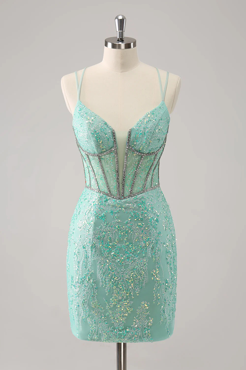 Model wearing a sparkling light green corset short homecoming dress with spaghetti straps, front view.