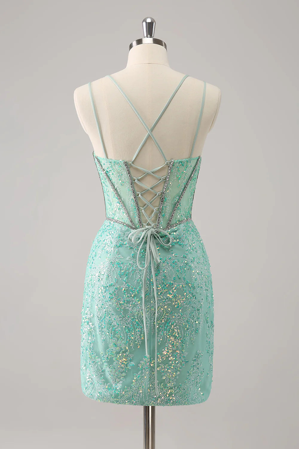 Back view of a model in a light green glitter corset short homecoming dress, showing lace-up detail.