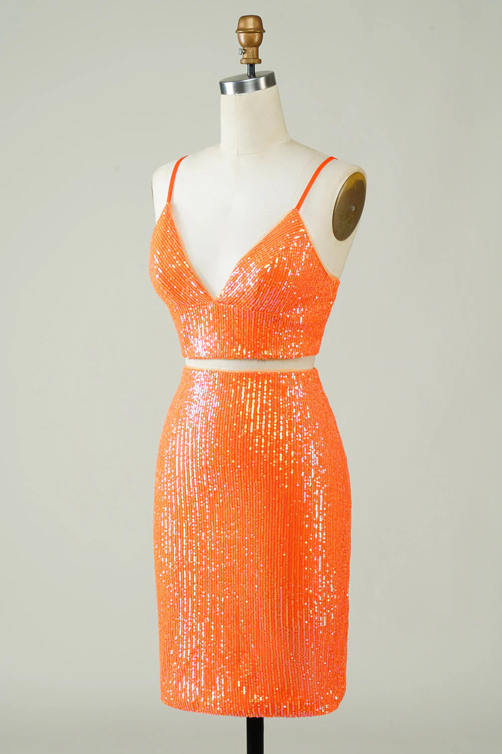Side view of the fitted orange sequin two-piece dress, highlighting the sparkling fabric.