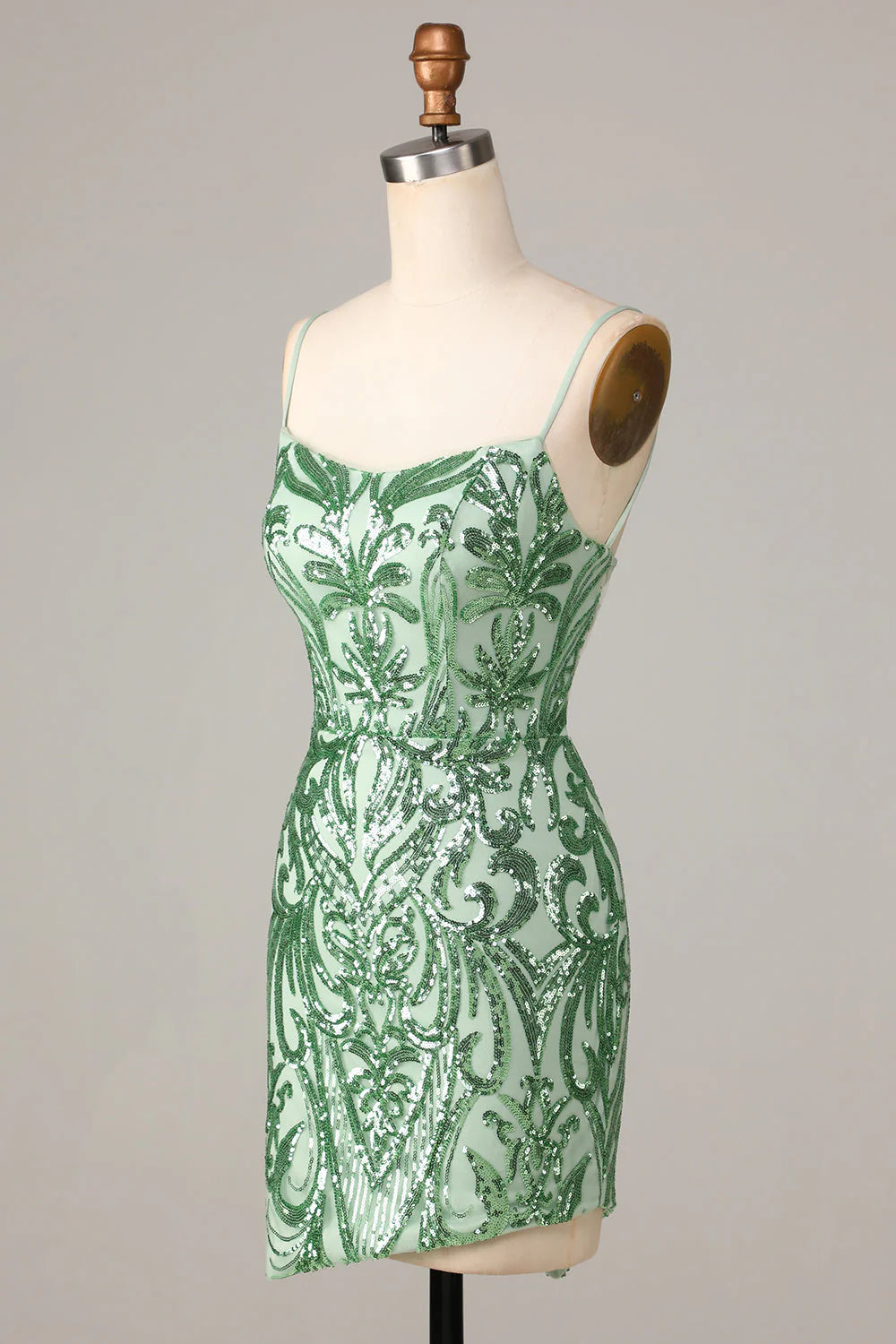 Side profile of a model wearing a short green sequin homecoming dress.