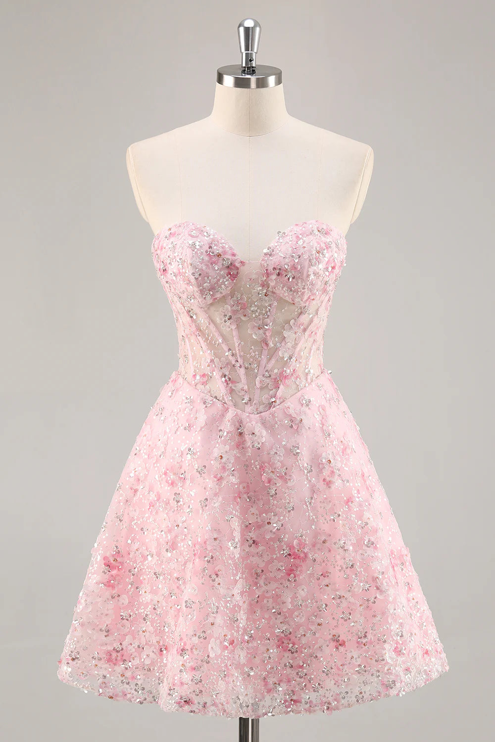 Model wearing a pink A-line strapless sequin short homecoming dress.