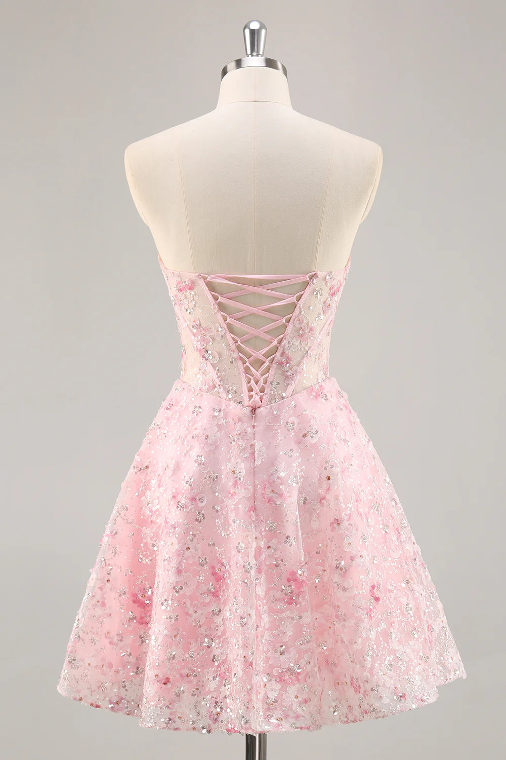 Back view of a pink A-line strapless sequin short homecoming dress.