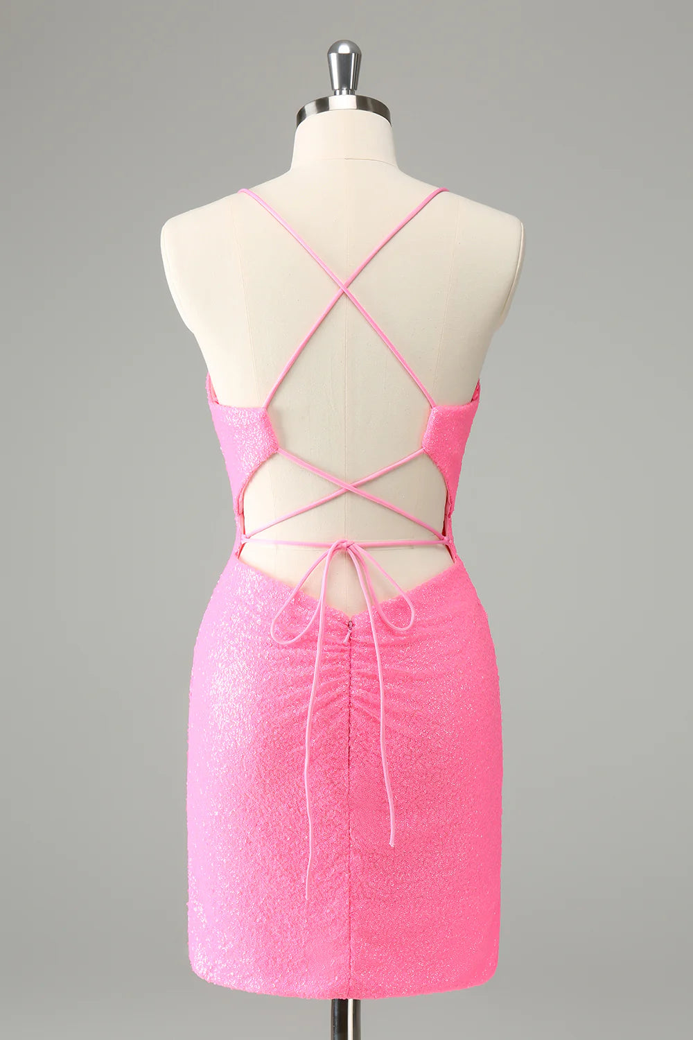 Back view of a pink sequined bodycon dress showing the lace-up detail.