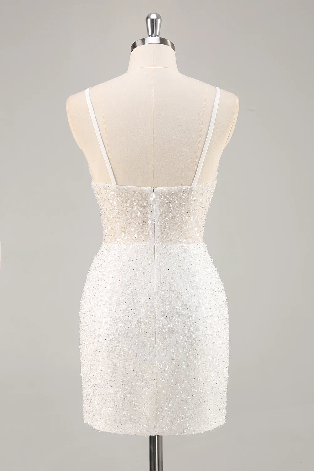 Close-up of sequin detail and spaghetti straps on the white dress.