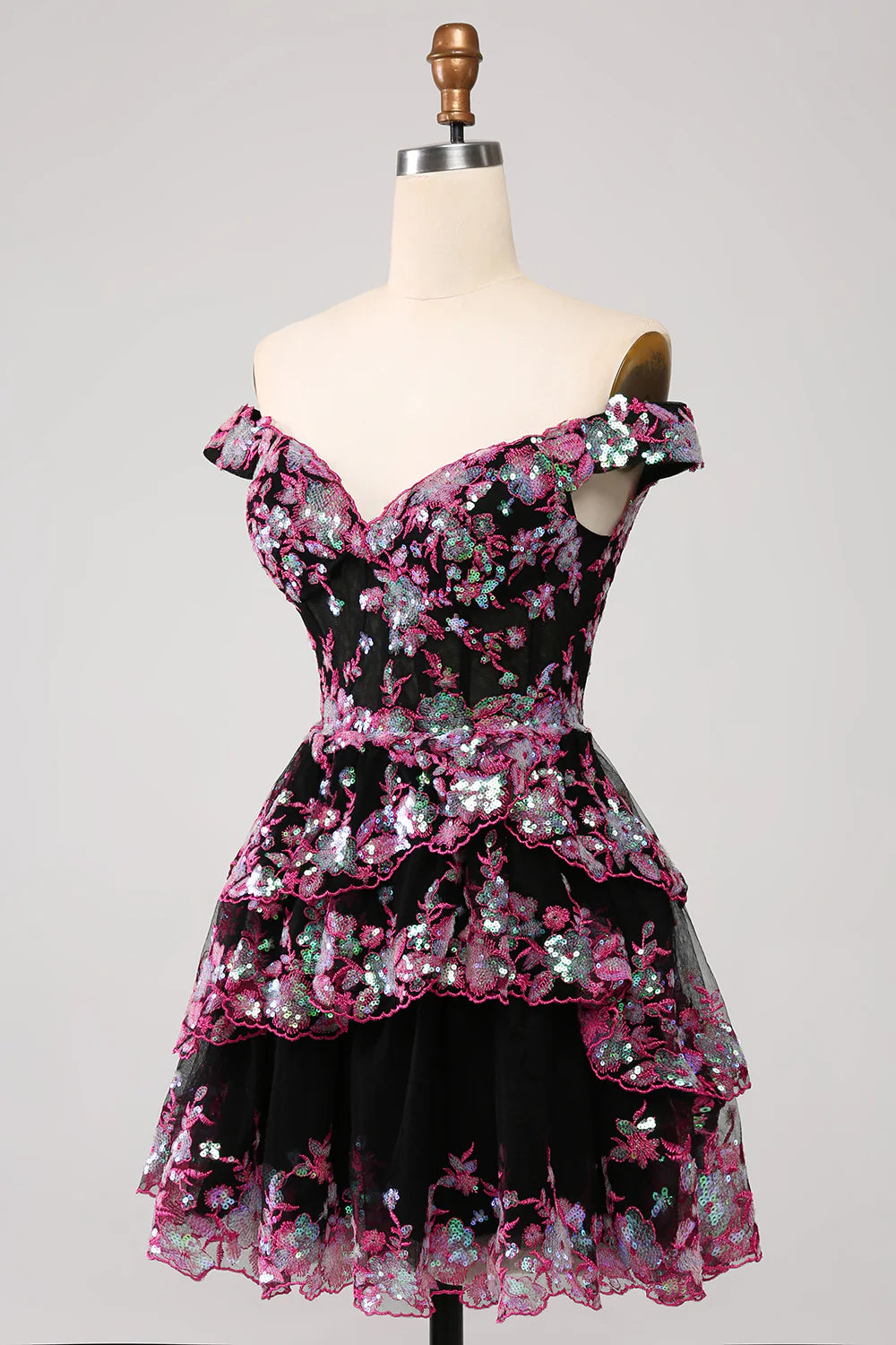 Close-up of the sparkly fabric and tiered detail on a black and pink homecoming dress.