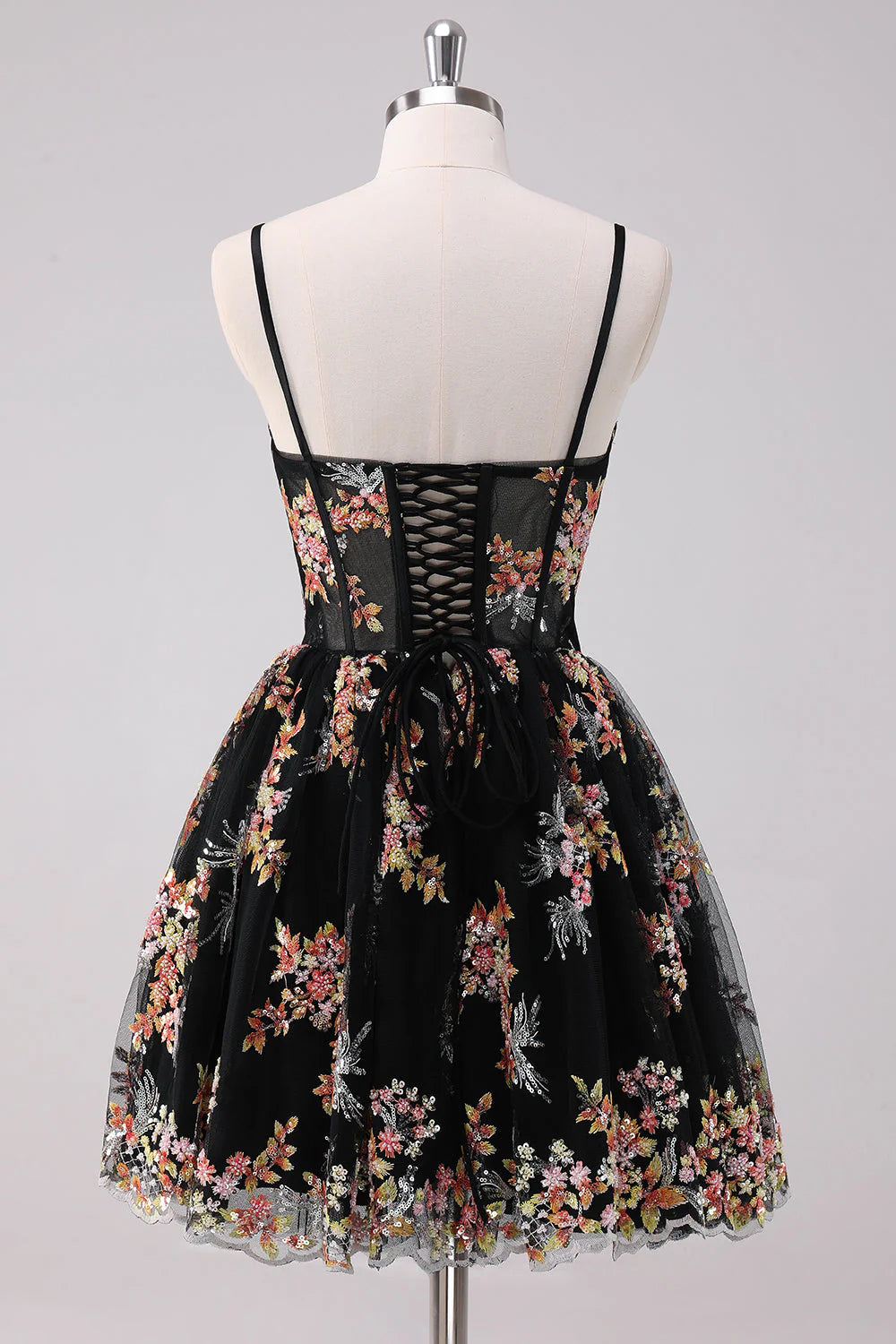 Side view of a short sparkly black floral party dress.